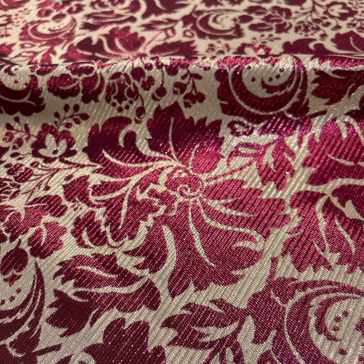Dettaglio dei motivi floreali luminosi del jacquard Bordeaux e Oro