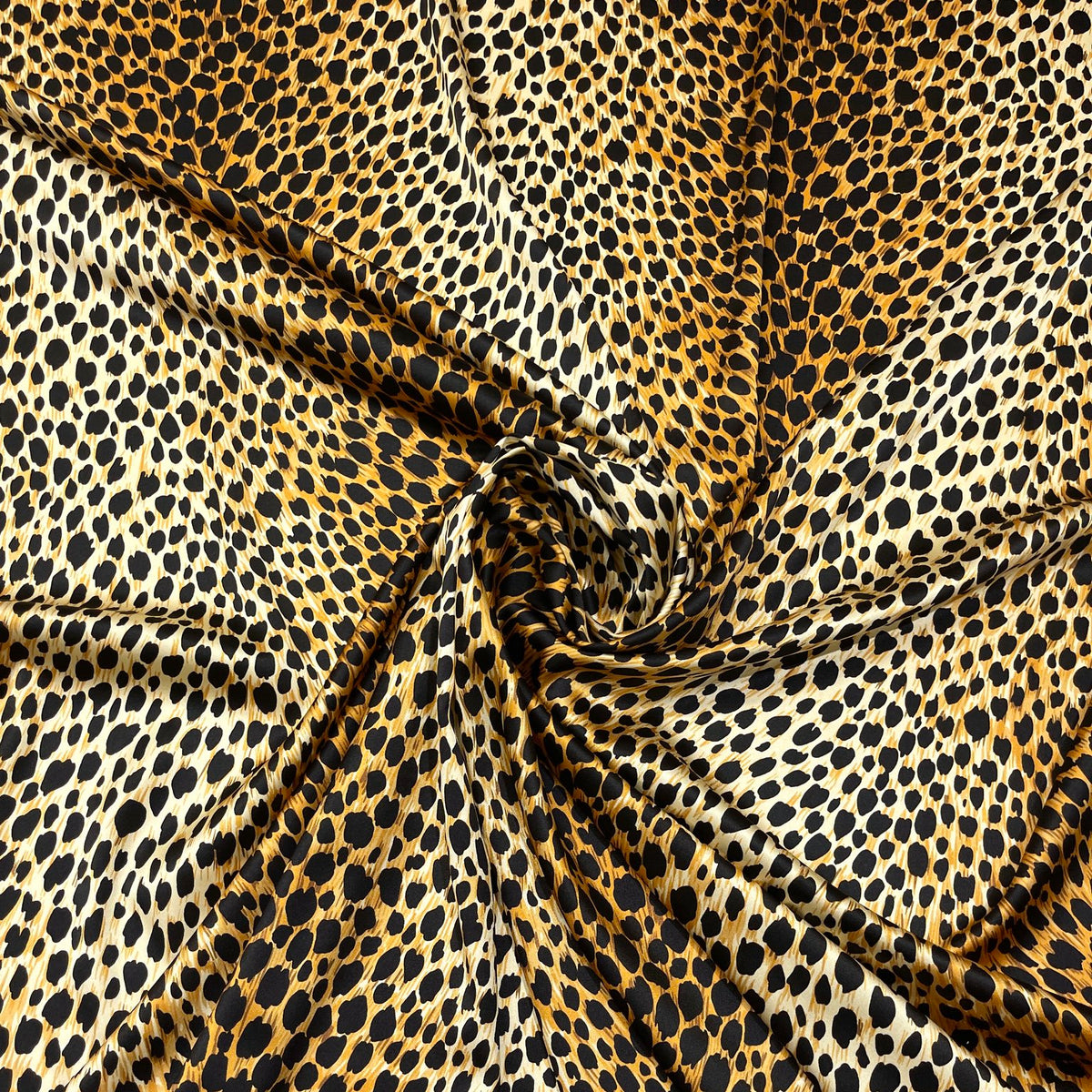 Seta elasticizzata con stampa animalier maculata, veduta del tessuto drappeggiato